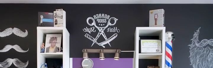 Pared negra de la barbería con bigotes dibujados, el emblema Barber Shop y un poste de barbero
